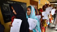 Residents hold their documents as they stand in a queue to check their names on the final list of National Register of Citizens (NRC) at a NRC Sewa Kendra (NSK) in Burgoan village in Morigoan district on July 30, 2018. (AFP / Biju BORO)