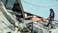 This picture taken on July 29, 2018 shows an Indonesian village security officer examining the debris of houses, after a 6.4 magnitude earthquake struck, in Lombok. AFP / Aulia Ahmad