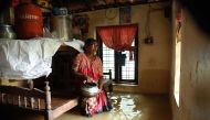 An Indian woman sits inside her houses immersed in flood waters in Ernakulam district of Kochi, in the Indian state of Kerala on August 10, 2018. AFP
 