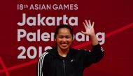 Hidilyn Diaz of Philippines celebrate at the podium during the victory ceremony for the women's 53kg weightlifting event during the 2018 Asian Games in Jakarta on August 21, 2018. / AFP / MONEY SHARMA