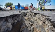 FILE PHOTO: People walk near a road damaged by earthquake at Kayangan Port in Lombok, Indonesia August 20, 2018. Antara Foto/Ahmad Subaidi
