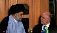 FILE PHOTO: Iraqi cleric Moqtada al-Sadr looks at Prime Minister Haider al-Abadi during a news conference in Najaf, June 23, 2018. (Reuters/Alaa al-Marjani) 