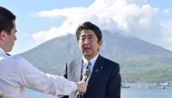 Japan's Prime Minister Shinzo Abe speaks to the media as he announces his candidacy for the upcoming ruling Liberal Democratic Party presidential election, during a press conference in front of Mount Sakurajima volcano while on tour to Tarumizu, Kagoshima