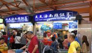 People have their lunch at the Maxwell hawkers centre in Singapore on August 30, 2018. (AFP / Roslan RAHMAN)