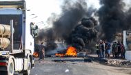 Iraqi protesters burn tires as they block the main road between the centre of the southern city of Basra leading towards Karmat Ali on its northern outskirts on September 2, 2018. / AFP / Haidar MOHAMMED ALI
