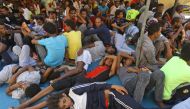 Illegal migrants sit inside the Ganzour shelter after being transferred from in the airport road due to fighting in the Libyan capital Tripoli on September 5, 2018.  AFP / Mahmud TURKIA
