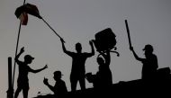 Iraqi protesters stand on concrete blast walls during an anti-government protest near the building of the government office in Basra, Iraq September 7, 2018. REUTERS/Alaa al-Marjani