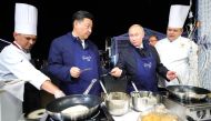 China's President Xi Jinping (2nd L) and Russia's President Vladimir Putin (2nd R) making bliny [Russian pancakes] as they visit the Far East Street exhibition on the sidelines of the 2018 Eastern Economic Forum on Russky Island in Vladivostok, Russia on 