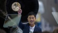 Japanese billionaire Yusaku Maezawa reacts near a Falcon 9 rocket during the announcement by Elon Musk to be the first private passenger who will fly around the Moon aboard the SpaceX BFR launch vehicle, at the SpaceX headquarters and rocket factory on Se