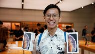 Singaporean Daniel Lim, 23, the first in line to buy the newly released iPhones, poses with his purchases at the Apple Store in Singapore September 21, 2018. Reuters/Edgar Su