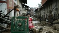 A woman sits on the ruins after typhoon Nepartak swept through Minqing county, Fujian province, China, July 10, 2016. (Reuters) 