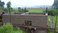 Kanchhi Rai cleans up the grass around her recently-erected home in the village of Raigaun, Nepal, August 5, 2018. Thomson Reuters Foundation/Arun Karki