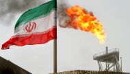 FILE PHOTO: A gas flare on an oil production platform in the Soroush oil fields is seen alongside an Iranian flag in the Persian Gulf, Iran, July 25, 2005. REUTERS/Raheb Homavandi