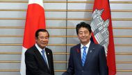 Japanese Prime Minister Shinzo Abe, right, and Cambodia's Prime Minister Hun Sen shake hands prior to their meeting at Abe’s office in Tokyo Monday, Oct. 8, 2018. Eugene Hoshiko/Pool via REUTERS