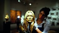 A Sotheby's employee poses with a bust of Kate Moss in solid 18-carat gold during a photocall for 'The Midas Touch' collection at Sotheby's in London, Britain, October 12, 2018. Reuters/Henry Nicholls