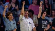 Brazilian presidential candidate for the Workers Party (PT), Fernando Haddad (C), his wife Ana Estela Haddad (L) and Brazilian vice presidential candidate Manuela D'Avila (R), lift their hands up during a campaign rally in Rio de Janeiro, Brazil on Octobe