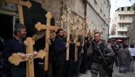 FILE PHOTO: Christian pilgrims carry wooden crosses along the path where Jesus walked, now known as the Via Dolorosa or the Way of Suffering on Good Friday in Jerusalem Old City on April 14, 2017. AFP/Gali Tibbon