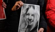 People hold a portrait of Gandyuk in front of the Ministry of Internal Affairs of Ukraine in remembrance of Ukrainian anti-corruption campaigner Kateryna Gandzyuk, seriously injured in an acid attack in July 2018 and who died in the hospital today, in Kie