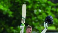 England's Keaton Jennings raises his bat and helmet in celebration after scoring a century (100 runs) during the third day of the opening Test match between Sri Lanka and England at the Galle International Cricket Stadium in Galle on November 8, 2018. AFP