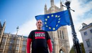 Spanish nurse and anti-Brexit campaigner Joan Pons Laplana poses for a photograph in front of an EU flag outside the Houses of Parliament in London on October 31, 2018. AFP / TOLGA AKMEN