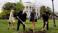 FILE PHOTO: Donald Trump and Emmanuel Macron shovel dirt onto a freshly planted oak tree as first lady Melania Trump and Brigitte Macron watch on the South Lawn of the White House, April 23, 2018. Reuters/Joshua Roberts