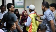 This picture taken on May 3, 2018 shows a woman (centre L) embracing her son after he and a group of young Indonesian men were found guilty of murdering 30-year-old Muhammad al-Zahra, at a court in Bekasi, West Java province. AFP/Bay Ismoyo
