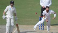 Pakistani spinner Yasir Shah (R) delivers the ball as New Zealand captain Kane Williamson (L) looks on during the third day of the second Test cricket match between Pakistan and New Zealand at the Dubai International Stadium in Dubai on November 26, 2018.