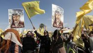 Supporters of Fatah movement's former security chief, Mohammed Dahlan, hold images of late Palestinian leader Yasser Arafat during a commemoration ceremony held on the occasion of the 14th anniversary of Arafat's death, on November 20, 2018 in Gaza city.