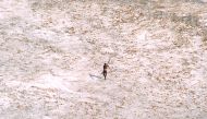 File photo of a Sentinel tribal man aims with his bow and arrow at an Indian Coast Guard helicopter as it flies over the island for a survey of the damage caused by the tsunami in India's Andaman and Nicobar archipelago, December 28, 2004. REUTERS/Indian 