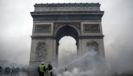  Demonstrators clash with riot police at the Arc de Triomphe during a protest of Yellow vests (Gilets jaunes) against rising oil prices and living costs, on December 1, 2018 in Paris. / AFP / Abdulmonam EASSA