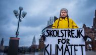 15-year-old Swedish girl Greta Thunberg holds a placard reading 