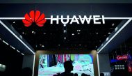 People walk past a sign board of Huawei at CES (Consumer Electronics Show) Asia 2018 in Shanghai, China June 14, 2018. Reuters/Aly Song