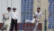 Pakistani spinner Yasir Shah (R) delivers the ball as New Zealand captain and batsman Kane Williamson (L) looks on during the first day of the third and final Test match between Pakistan and New Zealand at the Sheikh Zayed International Cricket Stadium in