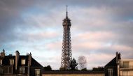 The top of the Eiffel Tower peeks out above the roofs on December 4, 2018 in Paris. AFP / Lionel Bonaventure