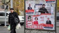 People walk past election posters in Yerevan on December 6, 2018, days before December 9 early parliamentary elections. / AFP / KAREN MINASYAN 