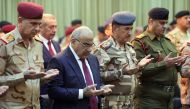 Iraqi PM Adel Abdel Mahdi (2nd-L) praying with military figures during a ceremony held in the capital Baghdad, on the first anniversary of the country's victory over the Islamic State (IS) group on December 10, 2018.  AFP photo/ Iraqi Prime Minister's Off