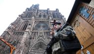 French soldiers stand guard at the Christmas market in front of the Cathedral, on December 12, 2018, as policemen conduct a search in order to find the gunman who opened fire near a Christmas market the night before, in Strasbourg, eastern France. AFP / P
