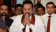 Sri Lanka’s former president Mahinda Rajapakse gestures during a ceremony before signing a document backing down from his controversial appointment as prime minister in Colombo on December 15, 2018.  AFP / LAKRUWAN WANNIARACHCHI