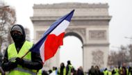 A protester wearing a yellow vest holds a French flag during a demonstration by the 
