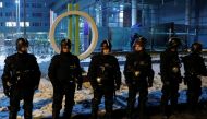 Police forces stand guard outside the headquarters of the Hungarian state television during a protest against a proposed new labor law, billed as the 