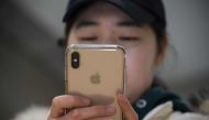 A woman uses an Apple iPhone at a shopping mall in Beijing on January 3, 2019. Apple cut its revenue outlook for the latest quarter on January 3, citing steeper-than-expected 
