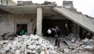 A Syrian man clears debris from a building that was damaged by a reported air strike in the rebel-held town of Orum al-Kubra, in the northern Syrian province of Aleppo, on January 5, 2019.   AFP / Aaref WATAD
