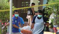Paramedics take away a body after four Thai civil defence volunteers were shot and killed outside of a school in the restive southern province of Pattani on January 10, 2019. AFP / Tuwaedaniya Meringing 