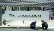In this file picture, workers set up the booth for British car manufacturer Jaguar Land Rover’s Jaguar brand inside the National Exhibition and Convention Center, the venue for the recently held China International Import Expo (CIIE), in Shanghai, China. 