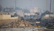 Afghan security forces gather at the site of a powerful truck bomb attack a day after it detonated near a foreign compound in Kabul on January 15, 2019. AFP / WAKIL KOHSAR
 