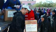 Qatar Red Crescent Society volunteers distributing aid. 