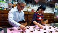 This photo taken on December 25, 2018 shows Lee Ching-chang (L) and his daughter Lee Chia-ling (R) working at their Chinese herbal medicine shop in New Taipei City.  / AFP / HSU Tsun-hsu 
