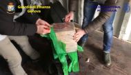 Police officers opening a bag filled with cocaine packs, after they were seized in a container at Genoa's harbour, coming from Colombia.
