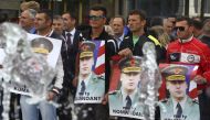 Protesters hold posters of Sylejman Selimi, a war commander during the 1998-1999 war, during a protest against a parliamentary vote to create a new war crimes court in Pristina, Kosovo May 29, 2015. Reuters/Hazir Reka