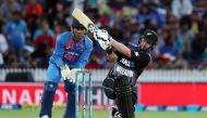New Zealand's Colin Munro (R) plays a shot as India's MS Dhoni (L) looks on, during the third Twenty20 international cricket match between New Zealand and India in Hamilton on February 10, 2019. (AFP / MICHAEL BRADLEY)